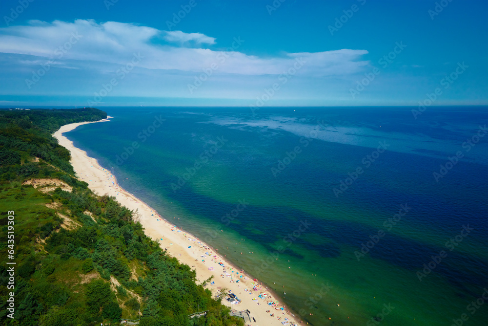Aerial view of sea landscape with crowded sand beach in Wladyslawowo. Baltic sea coastline with swimming people in Poland. Resort town in summer season