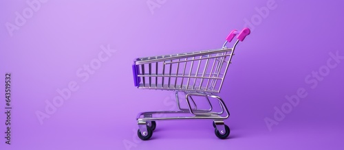 Purple background minimalist style shopping cart Creative design top view with space for text Supermarket shop trolley Sale discount shopaholic concept Consumer society trend