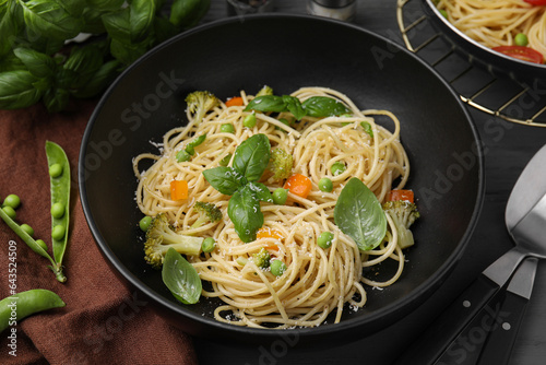 Delicious pasta primavera with basil, broccoli and peas served on table, closeup