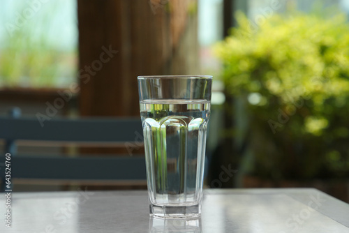 Glass of fresh water on table indoors