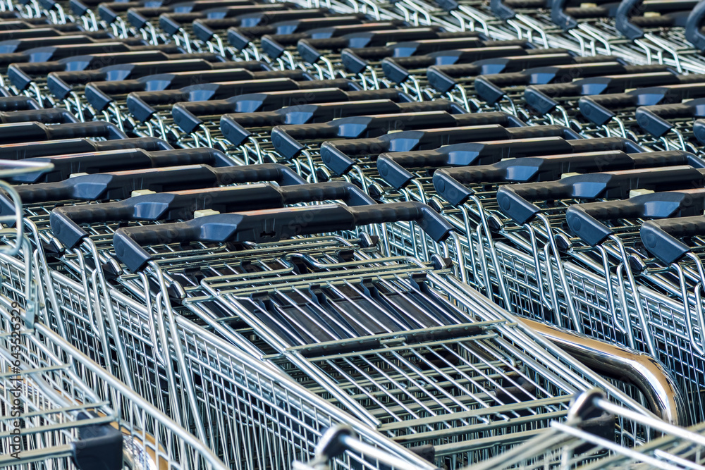 Stacked shopping trolley carts in front of the supermarket store, basket of goods concept