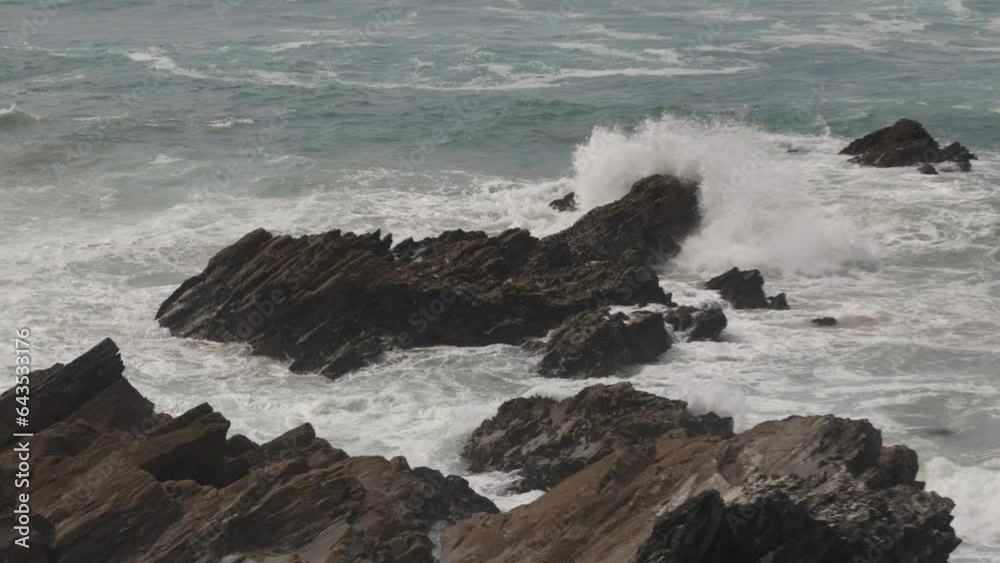 Slow motion shot of waves crashing against rocks off the Newquay coastline Slow motion shot of waves crashing against rocks off the Newquay coastline