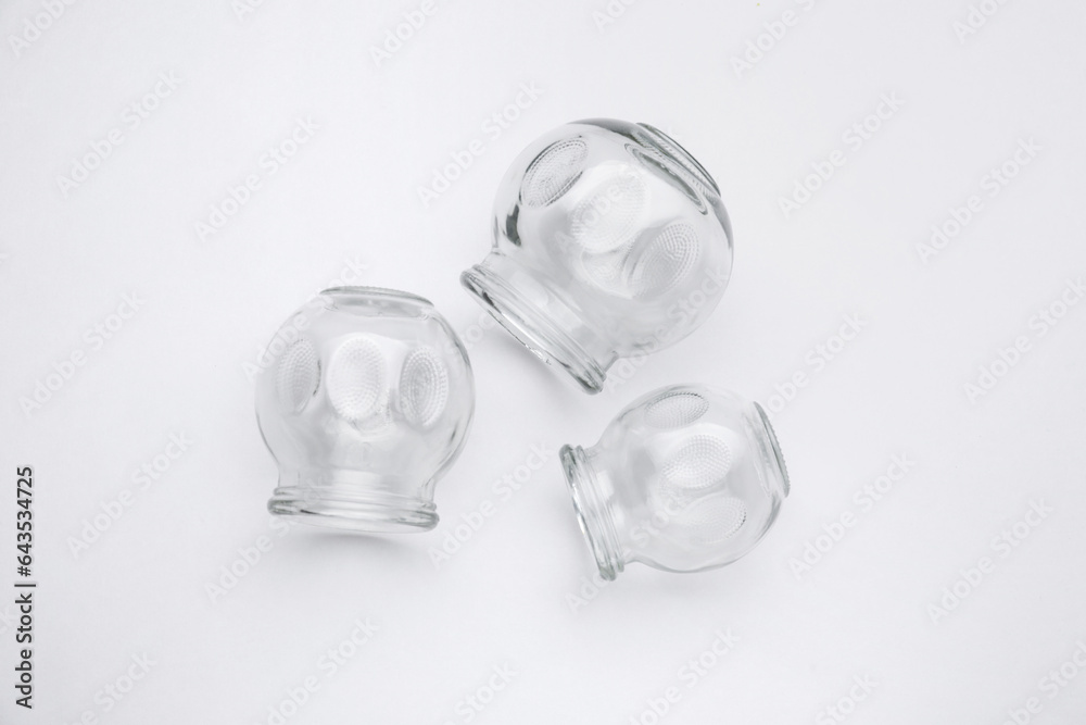 Glass cups on light grey background, flat lay. Cupping therapy Glass cups on light grey background, flat lay. Cupping therapy