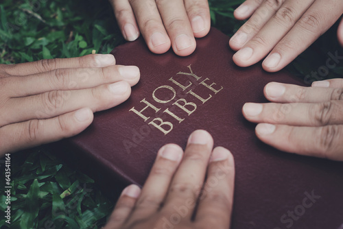 Human hands touching the scriptures. Concept. Belief in God. Living according to God\'s word Love God and study the Bible. Young people work together to touch scriptures to pray.