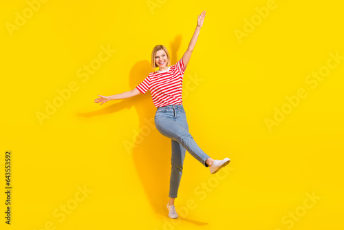 Full body portrait of overjoyed cheerful lady have good mood clubbing dancing isolated on yellow color background
