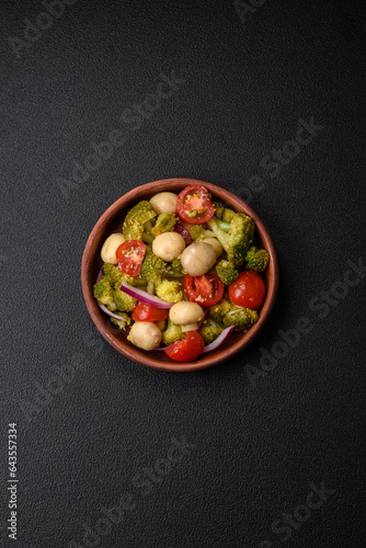 Delicious fresh salad with broccoli, cherry tomatoes, mushrooms, onions, salt, spices and herbs