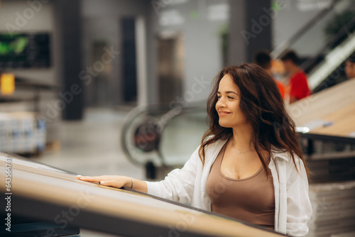 In warehouse of construction store with floor coverings, reflective customer is thinking about expediency of buying laminate flooring in this store photo