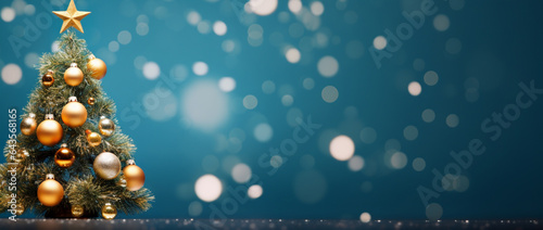 A Christmas tree adorned with a star and baubles on a gently blurred blue backdrop.