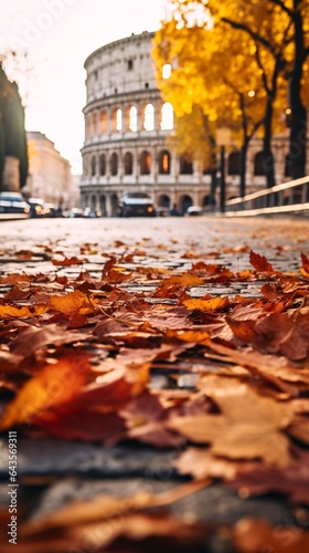 Fototapeta Naklejka Na Ścianę i Meble -  storied streets of Rome during the fall. Focus on the fallen leaves scattered on the ancient Roman cobblestones, with the Colosseum standing majestically in the background