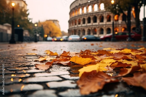 Fototapeta Naklejka Na Ścianę i Meble -  storied streets of Rome during the fall. Focus on the fallen leaves scattered on the ancient Roman cobblestones, with the Colosseum standing majestically in the background