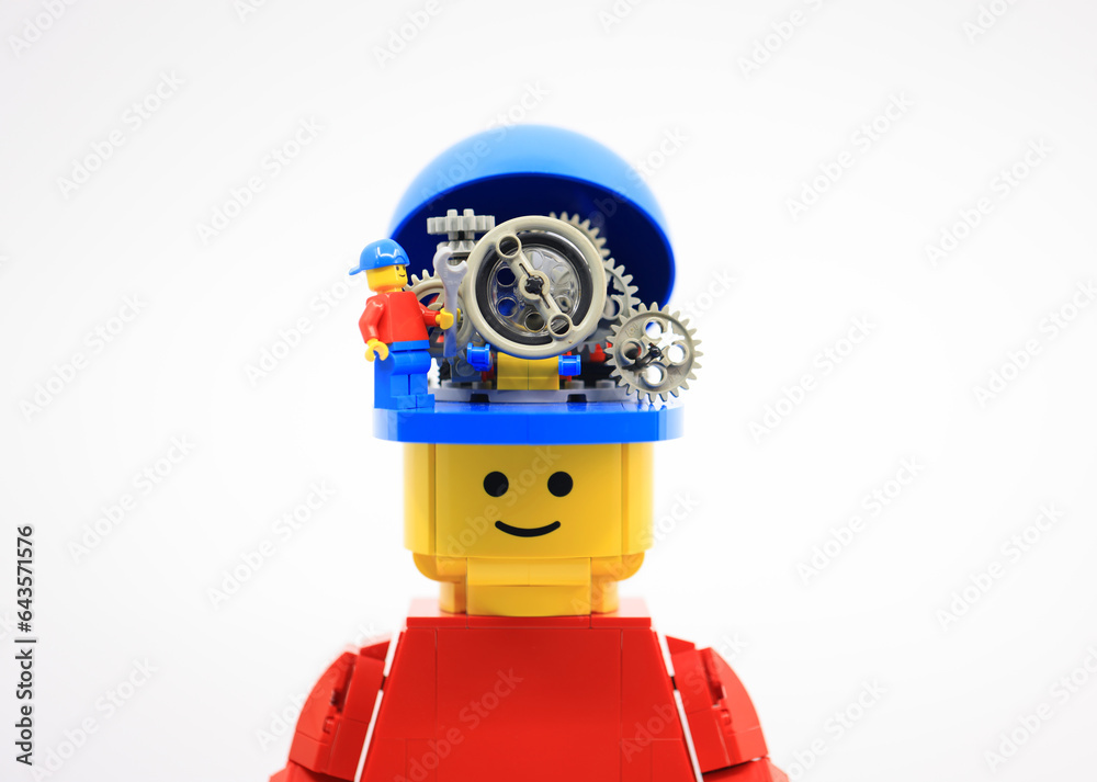 Fototapeta premium Hong Kong - September 2 2023: small worker fix the gear wheels in the head of giant man