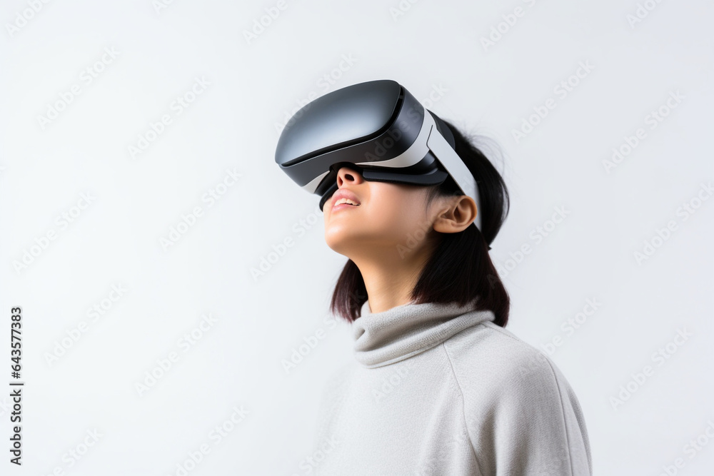 Young woman wearing virtual reality VR glasses, VR headset and trying to touch something with her hand while standing on white background. Young woman wearing virtual reality VR glasses, VR headset and trying to touch something with her hand while standing on white background.
