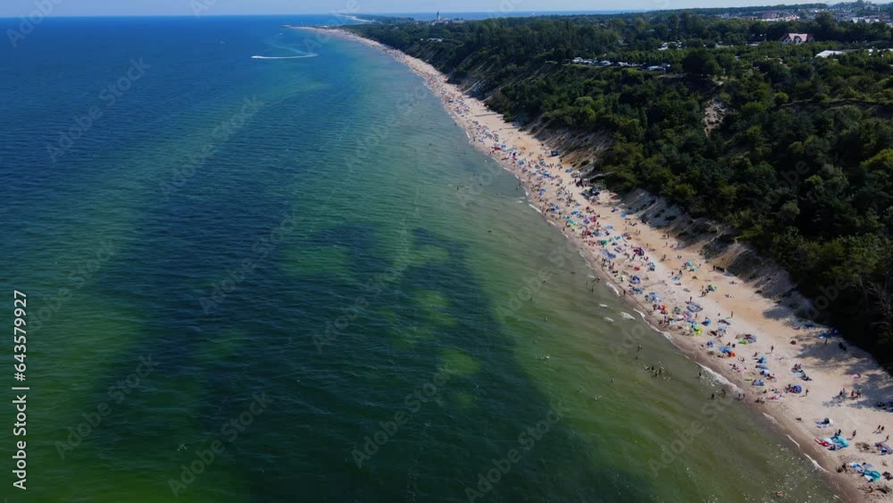 Aerial view of sea landscape with crowded sand beach in Wladyslawowo. Baltic sea coastline with swimming people in Poland. Resort town in summer season Aerial view of sea landscape with crowded sand beach in Wladyslawowo. Baltic sea coastline with swimming people in Poland. Resort town in summer season