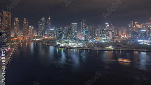 Cityscape with skyscrapers of Dubai Business Bay and water canal aerial night timelapse. © neiezhmakov