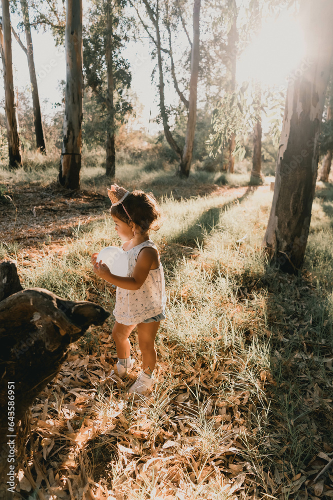 Naklejka premium Portrait of a baby girl playing in an autumn landscape on her birthday
