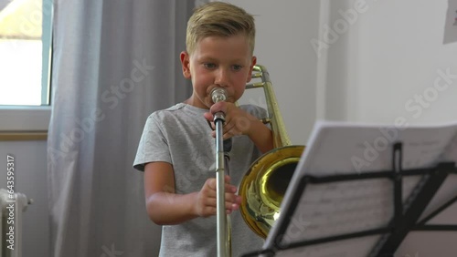 Committed Caucasian boy is practicing trombone.