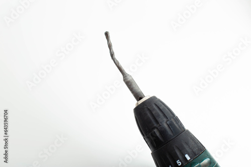 Poor quality broken metal drill on a white background, close-up photo