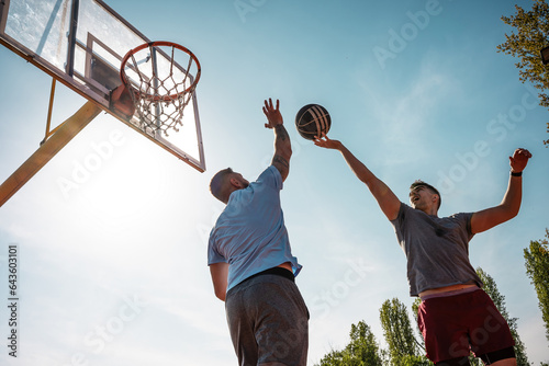 A guy challenge his friend to play street basketball.    © BalanceFormCreative