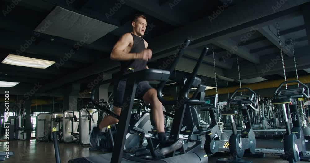 Strong athletic man doing intense cardio workout and running fast on treadmill at fitness club. Active sportsman male jogging at modern gym. Healthy lifestyle concept