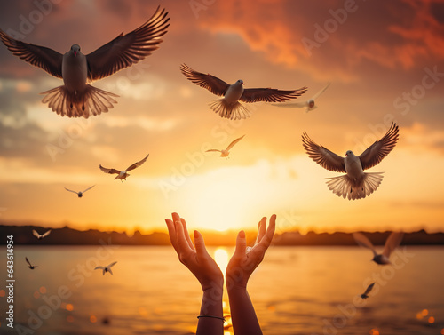 Obraz na płótnie Hands open palm up worship with birds flying over calm water sunset background