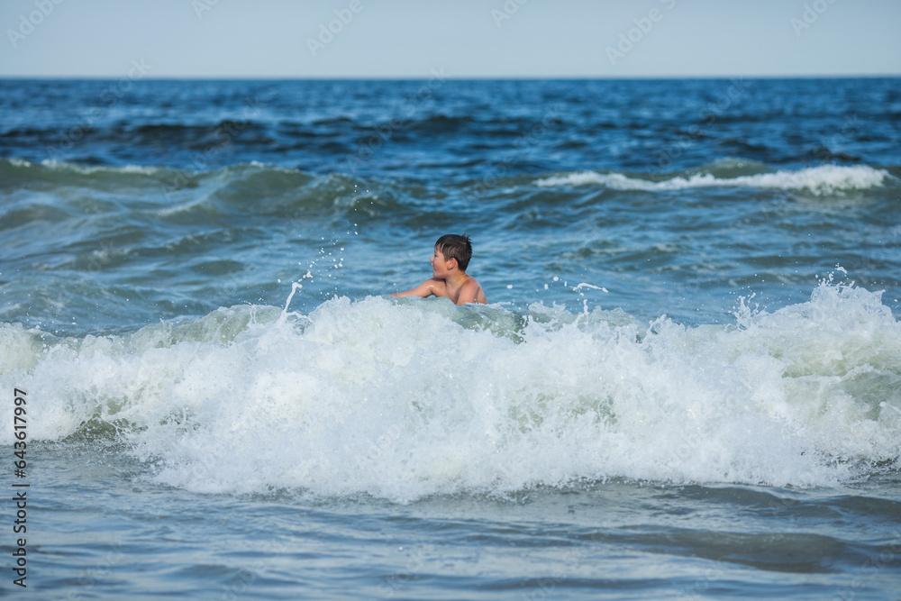 Cheerful teenage boy with a swimming board. Happy european family having fun floating on a swim board in the ocean on a hot summer day Cheerful teenage boy with a swimming board. Happy european family having fun floating on a swim board in the ocean on a hot summer day