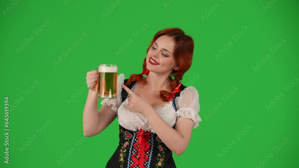 Medium green screen isolated chroma key video of a young German woman, waitress, wearing a traditional costume, holding a glass of lager, beer, pointing at it, showing OK sign. Medium green screen isolated chroma key video of a young German woman, waitress, wearing a traditional costume, holding a glass of lager, beer, pointing at it, showing OK sign.
