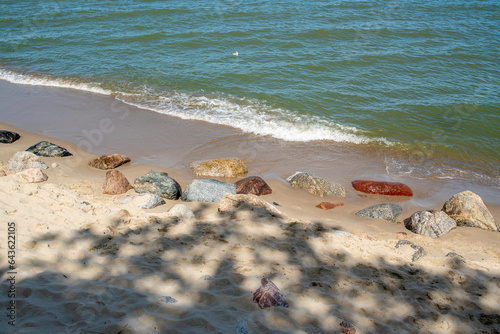 Fototapeta Naklejka Na Ścianę i Meble -  Large stones in the sand near the water on the shore of the Baltic Sea