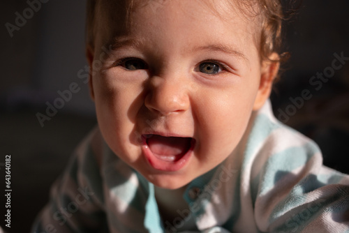 Cute white 9-month baby girl smile. Dark black background.