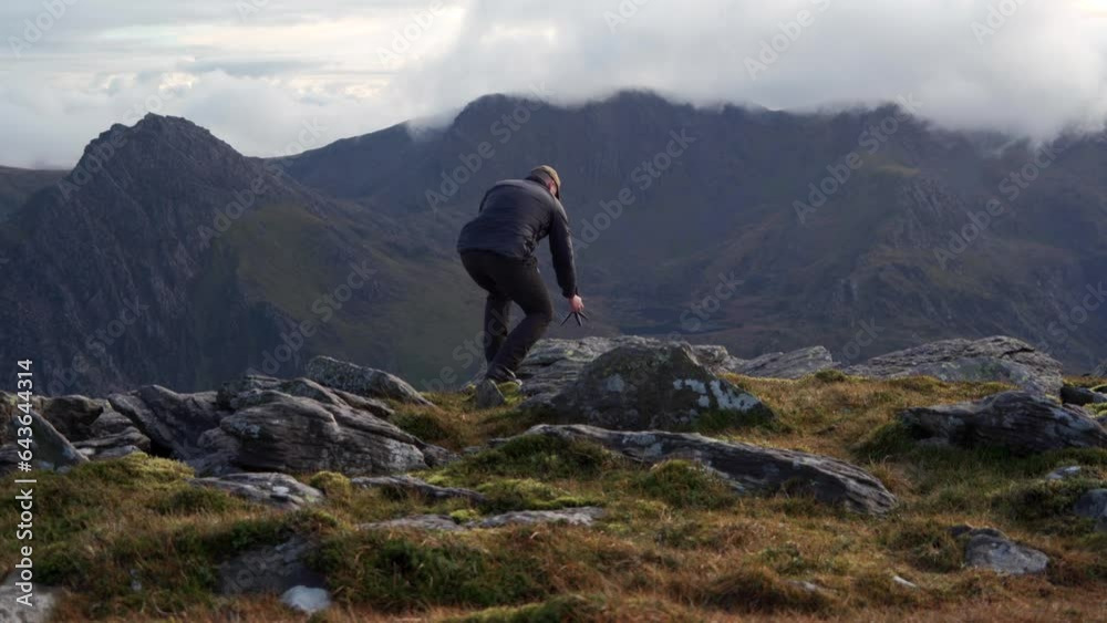 A photographer setting up a camera in a mountain landscape A photographer setting up a camera in a mountain landscape