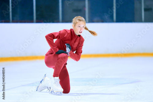 Challenges. Girl, figure skating athlete in red sportswear falling down during training on ice rink arena. Concept of professional sport, competition, sport school, health, hobby, ad