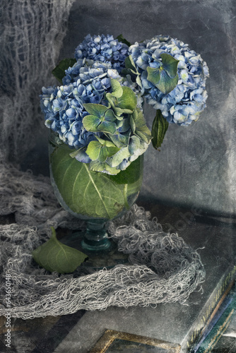 Beautiful hydrangea flowers in a vase on a blue background .Soft focus.
