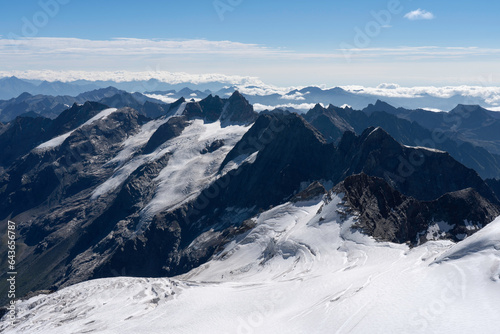 View from Gran Paradiso (National Park) mountain summit: glaciers of the massif and high rocky peaks. Mountains landscape.
