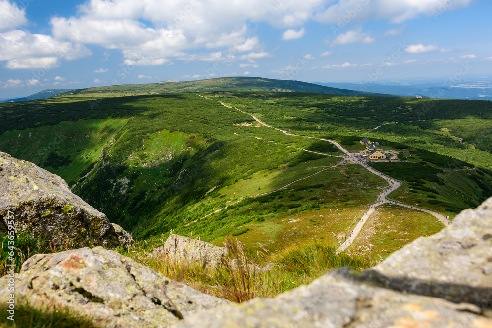 Fototapeta premium Giant Mountains, mountain panorama from the hiking trail to the top of Sniezka. View of the vast mountain slopes and trails on a sunny summer day.
