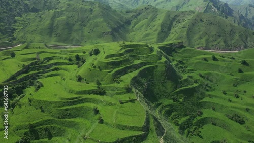 Flying forward over famous green Chokh terraces located in Andalal valley in Dagestan highlands. Aerial view of scenery green hills