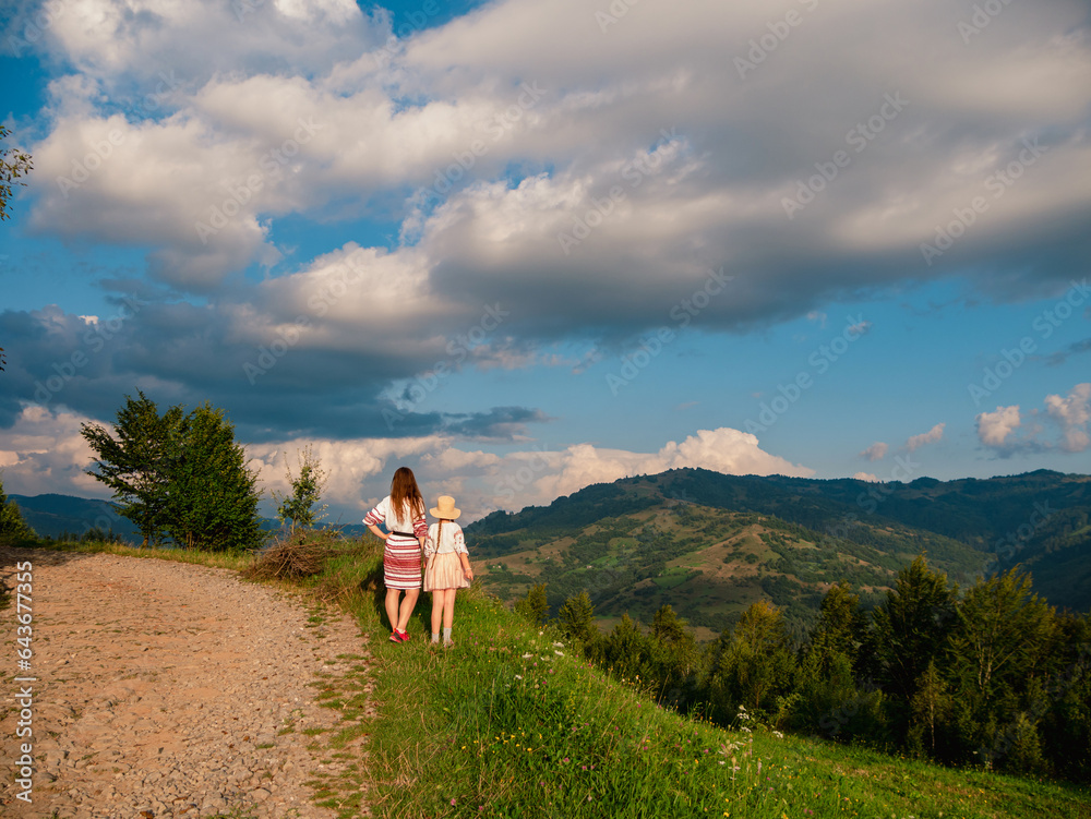 Ukrainian women in authentic costumes Mother and daughter in embroidered shirts standing on beautiful Carpathian Mountains peak scenic view. Independence day of Ukraine Zakarpattya Local travel Europe