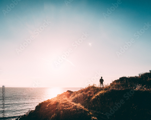 silhouette of a man on a cliff