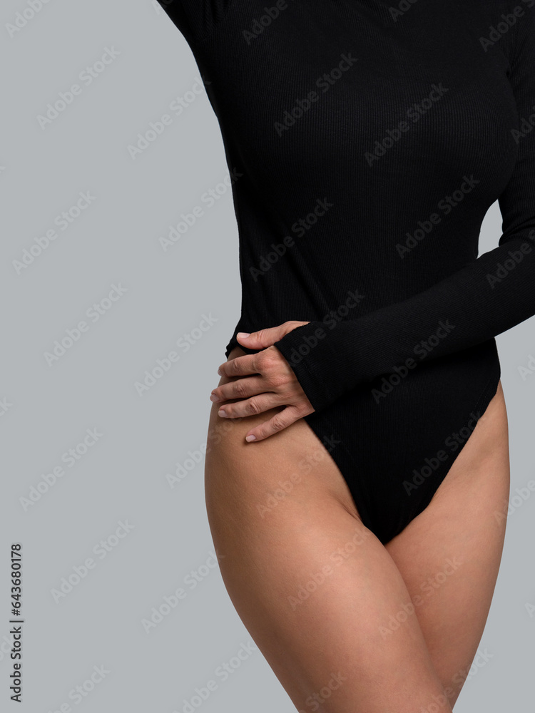 Fototapeta premium Female body in black bodysuit. Smooth skin in bikini area