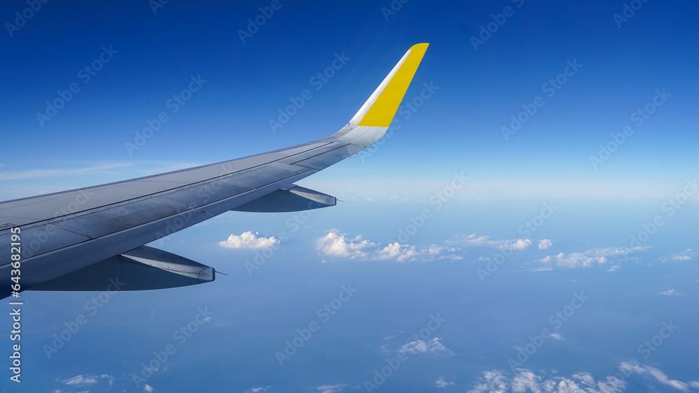 Fototapeta premium Airplane wing on a background of blue sky flight time