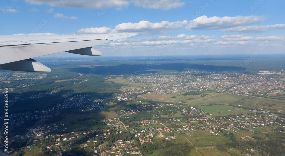 Beautiful view from above to the ground from the window of an airplane flying above the clouds. Shadows from clouds on the Earth's surface Beautiful view from above to the ground from the window of an airplane flying above the clouds. Shadows from clouds on the Earth's surface
