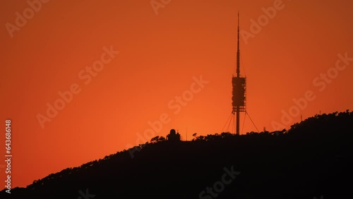 Setting sun (sunset) over Barcelona city skyline, Tibidabo mountain, and Collserola TV tower, Spain photo