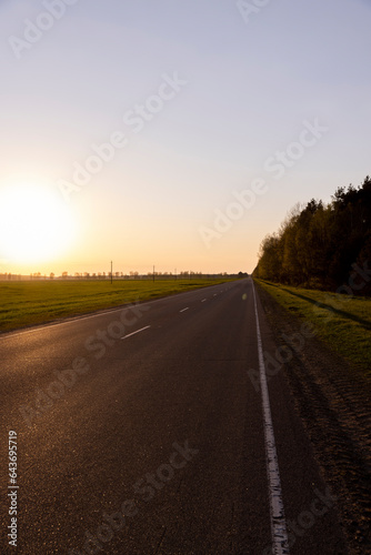 paved road at dusk during sunset, empty road