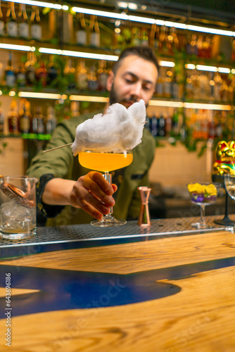 bartender hands a fresh bright tasty cocktail to a guest in a bar or restaurant close-up of hands