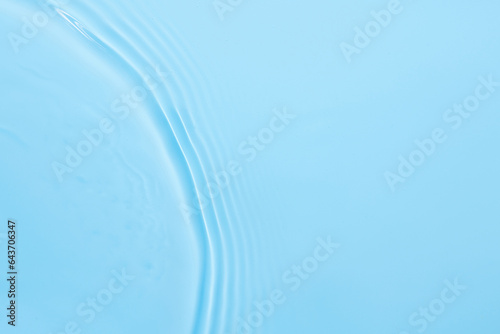 Water blue surface abstract background. Waves and ripples texture of cosmetic aqua moisturizer with bubbles