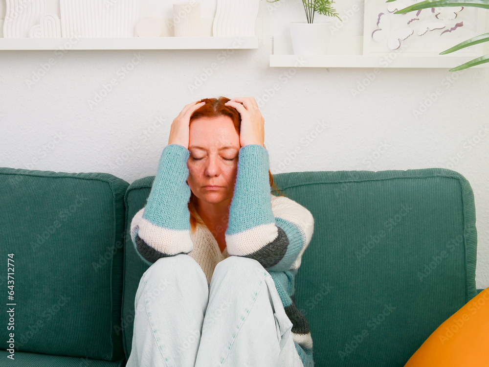Depression. Woman sitting alone on sofa in depressed mood