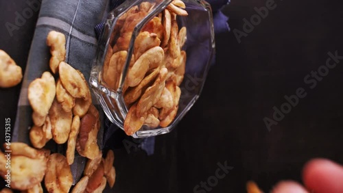Vertical video of man taking some toast avas from glass pot on black background photo