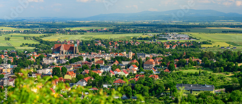 Strzegom, view of the city from the viewpoint on the top of Krzyzowa Mountain. Vast landscape for urban buildings with mountains in the background, summer sunny day.
