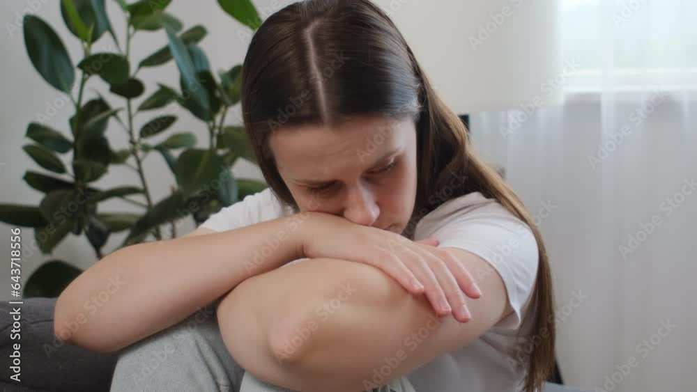 Unhappy thoughtful young caucasian woman looking in distance, feeling depressed, thinking about problems, sitting alone on couch at home, upset frustrated girl suffering from break up or divorce