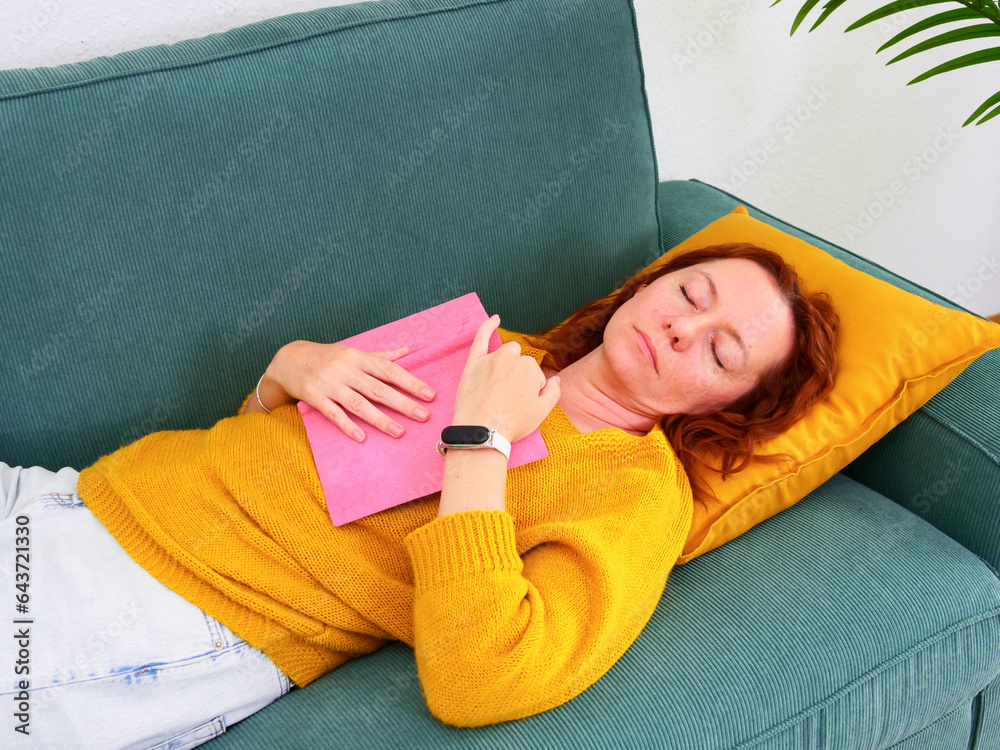 woman sleep on the sofa with the book, diary or planner