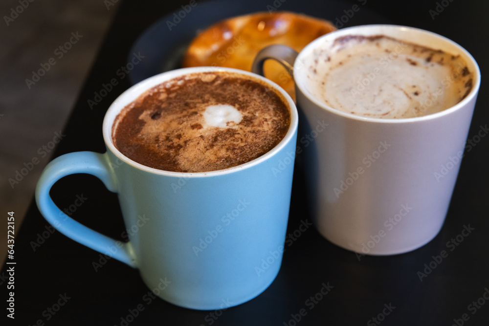 Two Cappuccino cups. Mugs full of coffee with milk foam Two Cappuccino cups. Mugs full of coffee with milk foam