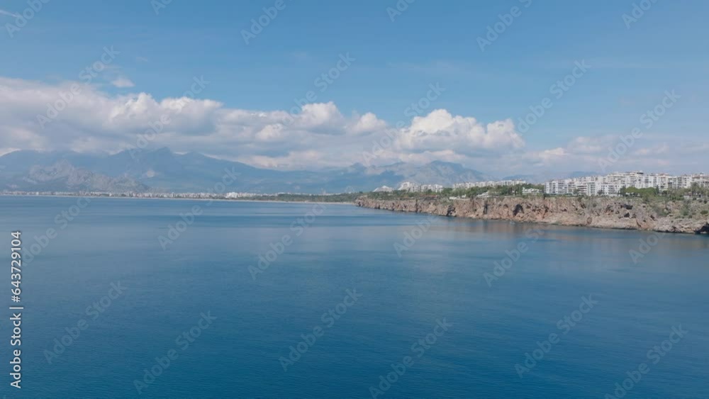 Forwards fly above water surface. Apartment buildings in travel destination. Urban borough on rocky cliff. Antalya, Turkey Forwards fly above water surface. Apartment buildings in travel destination. Urban borough on rocky cliff. Antalya, Turkey